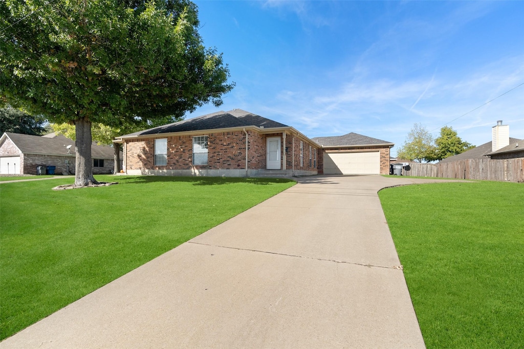 ranch-style house featuring a garage and a front lawn