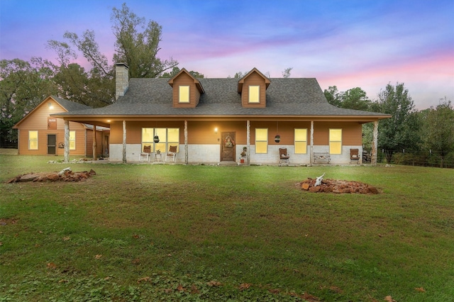 view of front facade featuring covered porch and a yard