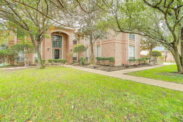 view of front of home featuring a front lawn and brick siding