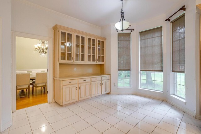 kitchen with a tile fireplace, crown molding, hanging light fixtures, kitchen peninsula, and stainless steel appliances