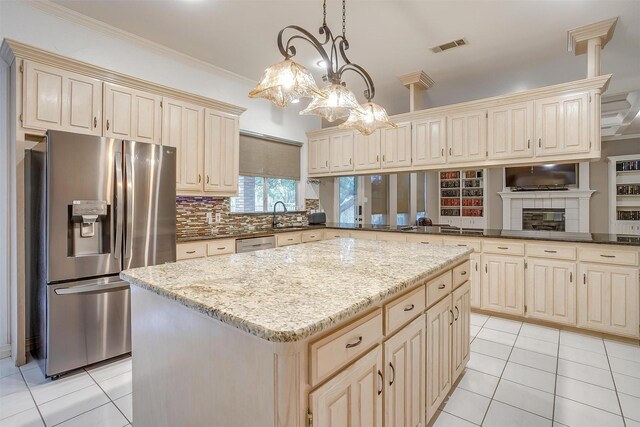 kitchen featuring double oven, a kitchen island, beverage cooler, and decorative light fixtures