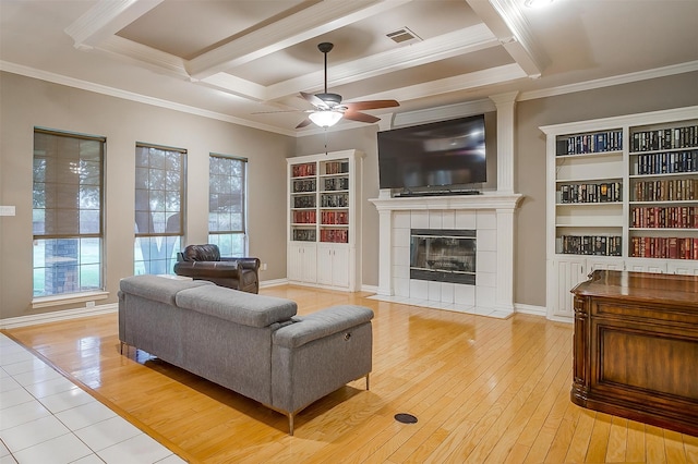 living room featuring a tile fireplace, ceiling fan, light hardwood / wood-style floors, and ornamental molding