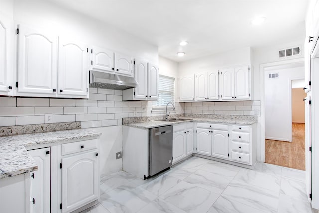 kitchen with sink, dishwasher, white cabinetry, tasteful backsplash, and light stone countertops