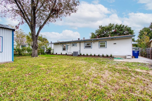 back of property with a lawn, central air condition unit, and a patio area