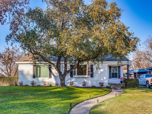 view of property hidden behind natural elements with a front yard