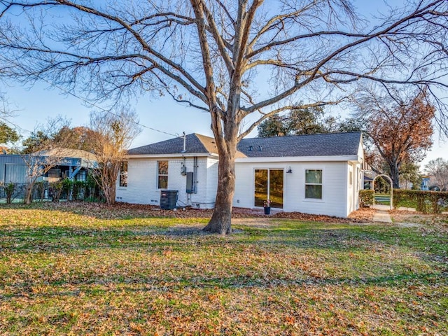 rear view of property with brick siding, a lawn, and cooling unit