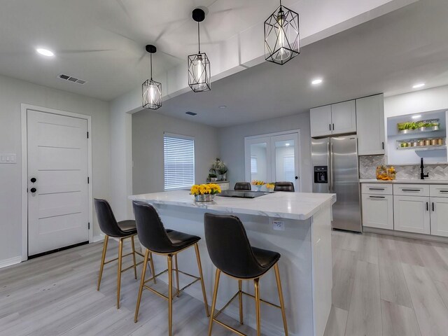 kitchen with tasteful backsplash, a wealth of natural light, electric stove, sink, and white cabinetry