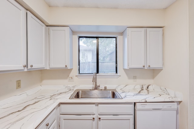 kitchen with light stone counters, white dishwasher, sink, and white cabinets