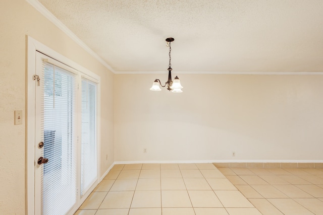 tiled empty room featuring a chandelier, a textured ceiling, and ornamental molding