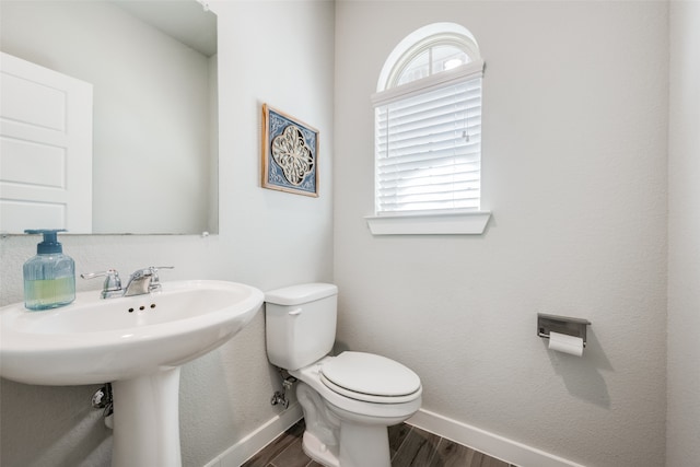 bathroom with toilet, wood-type flooring, and sink