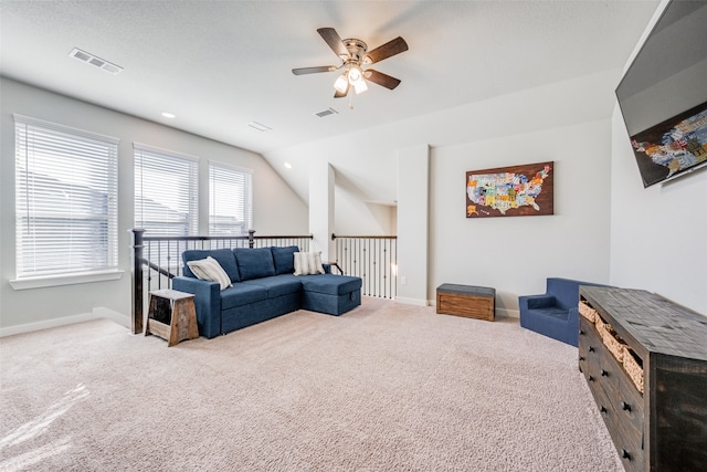 living room with ceiling fan, light carpet, and lofted ceiling