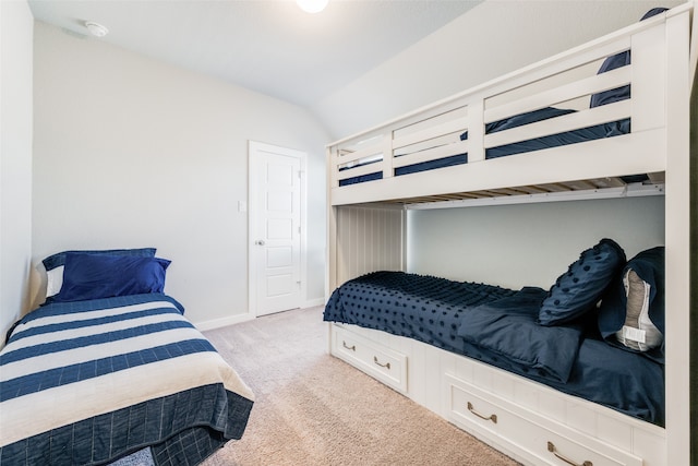 bedroom featuring light colored carpet and vaulted ceiling