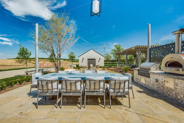 view of patio / terrace with a pergola, a grill, and exterior kitchen