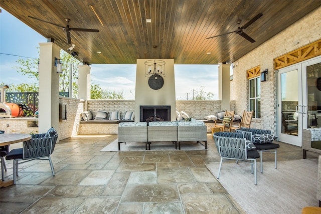 view of patio / terrace featuring an outdoor living space with a fireplace and ceiling fan