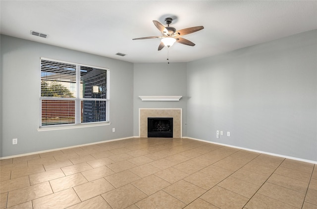 unfurnished living room with light tile patterned floors, a tile fireplace, and ceiling fan