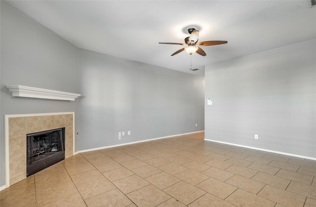 unfurnished living room with a tiled fireplace, light tile patterned floors, and ceiling fan