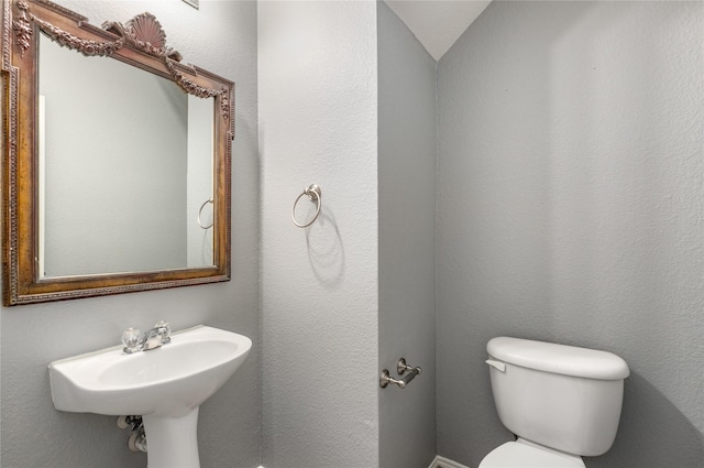 bathroom featuring lofted ceiling and toilet