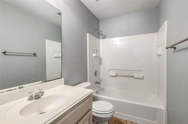 full bathroom with vanity, tub / shower combination, a textured ceiling, and toilet