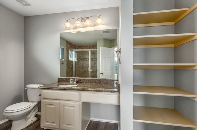 bathroom featuring an enclosed shower, vanity, wood-type flooring, and toilet