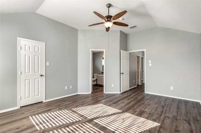 unfurnished bedroom with high vaulted ceiling, dark wood-type flooring, ceiling fan, and ensuite bath