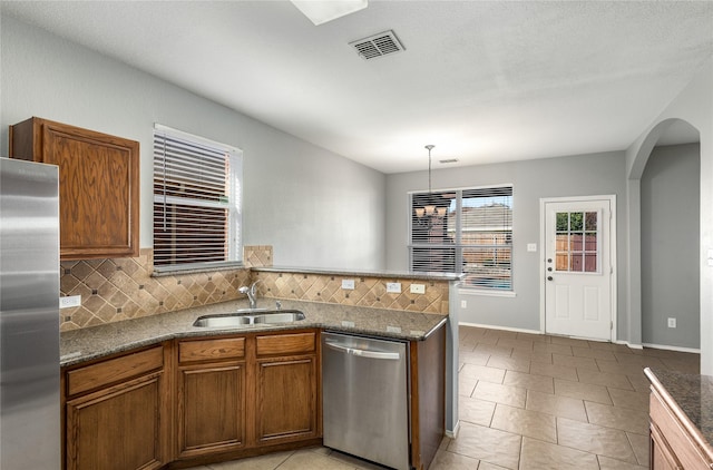 kitchen featuring pendant lighting, sink, light tile patterned floors, appliances with stainless steel finishes, and backsplash