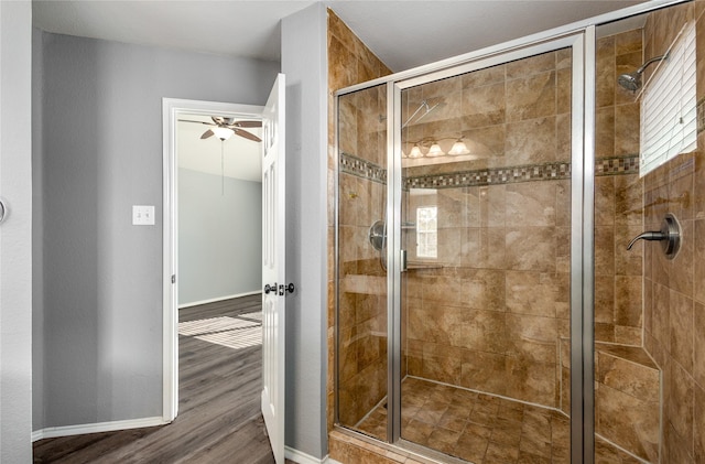 bathroom with hardwood / wood-style floors, ceiling fan, and walk in shower