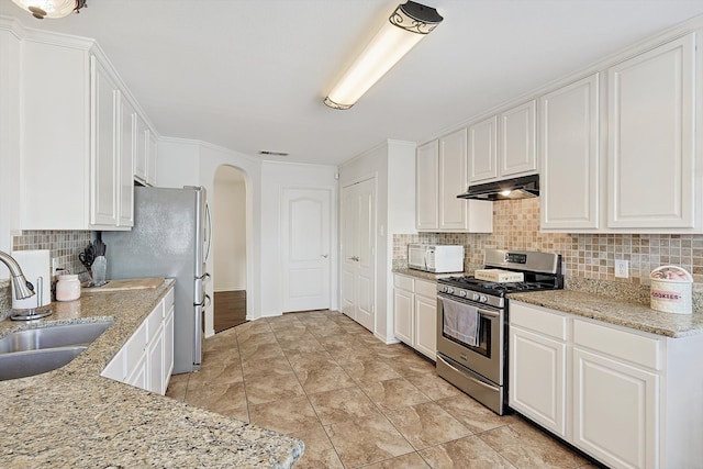 kitchen featuring white cabinets, light stone counters, sink, and appliances with stainless steel finishes