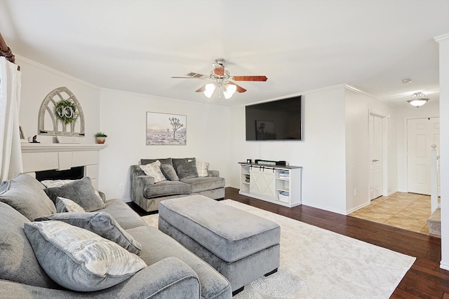 living room featuring ceiling fan, wood-type flooring, and ornamental molding