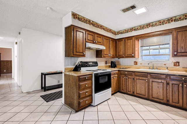 kitchen featuring a textured ceiling, sink, light tile patterned floors, and white electric stove