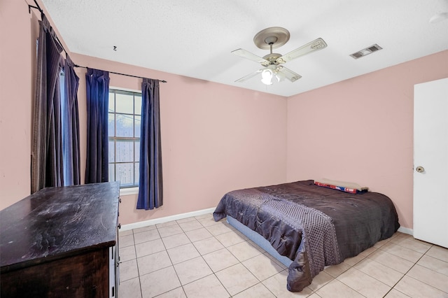 bedroom featuring a textured ceiling, ceiling fan, and light tile patterned flooring