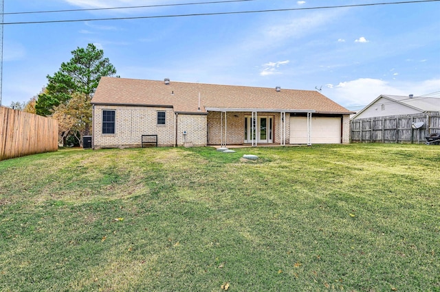 back of property featuring french doors, central AC unit, and a lawn