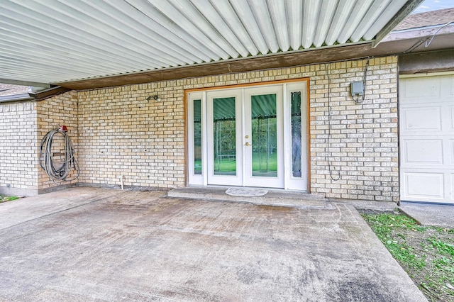 view of exterior entry featuring french doors and a patio area