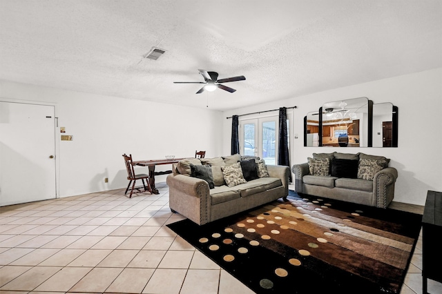 living room with ceiling fan, light tile patterned flooring, a textured ceiling, and french doors