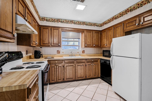 kitchen with sink, light tile patterned flooring, black appliances, and a textured ceiling