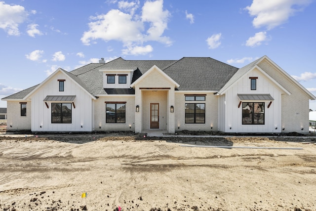 view of front of property featuring a standing seam roof, brick siding, board and batten siding, and roof with shingles