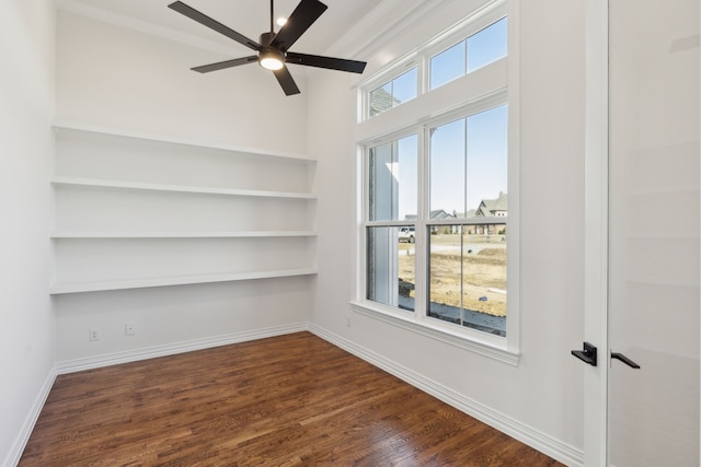 unfurnished room with a ceiling fan, crown molding, baseboards, and dark wood-style flooring