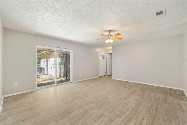 unfurnished room with ceiling fan, light hardwood / wood-style flooring, and a textured ceiling