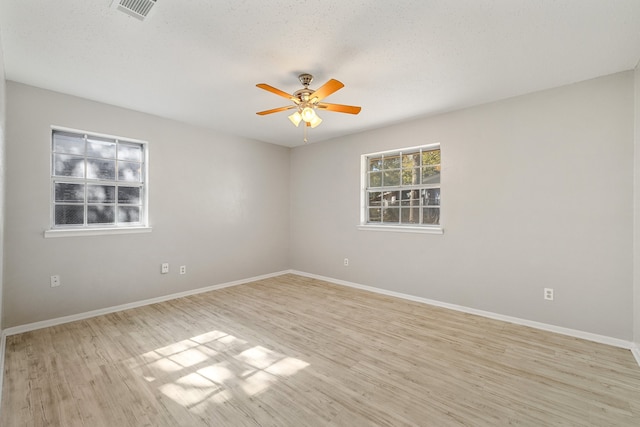 empty room featuring ceiling fan, a textured ceiling, and light wood-type flooring