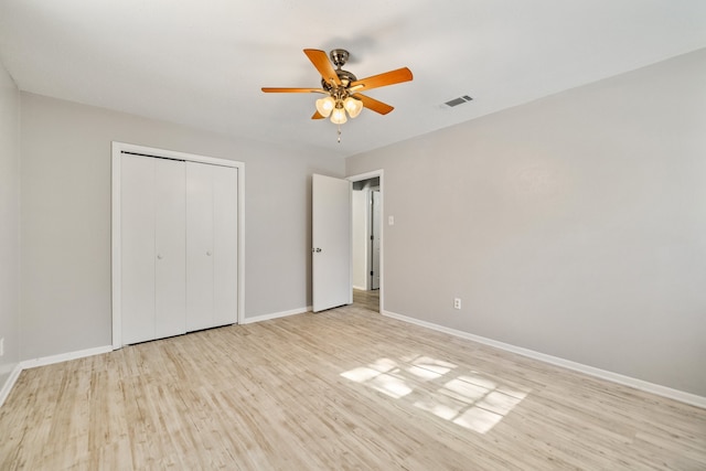 unfurnished bedroom featuring ceiling fan, a closet, and light hardwood / wood-style flooring