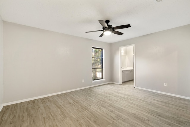 unfurnished bedroom featuring a textured ceiling, light hardwood / wood-style flooring, ensuite bath, and ceiling fan