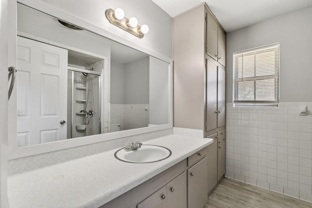 210 Skylark Dr, Azle, TX 76020 - full bathroom with tile walls, toilet, vanity, a shower stall, and a wainscoted wall