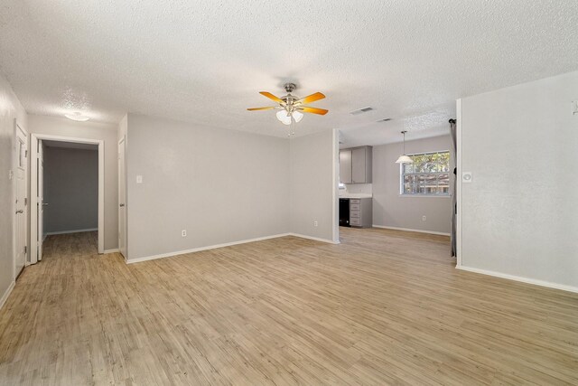 kitchen with dishwasher, sink, light hardwood / wood-style flooring, white refrigerator, and a textured ceiling