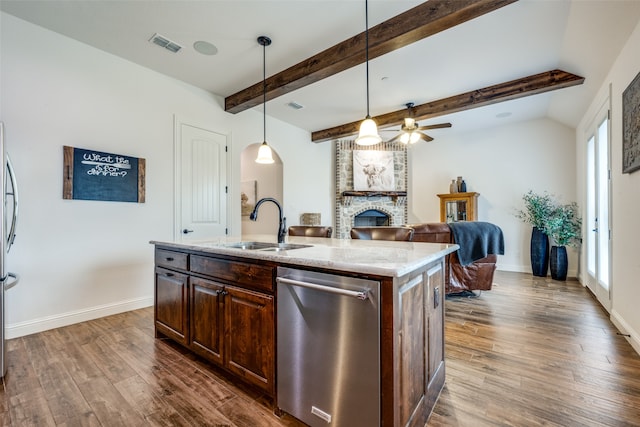 kitchen featuring dark wood-type flooring, a center island with sink, pendant lighting, and plenty of natural light