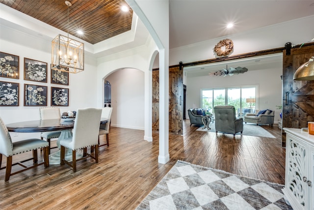 dining area with a barn door, wood-type flooring, and wood ceiling