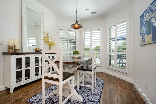 dining room featuring crown molding, dark hardwood / wood-style flooring, and a healthy amount of sunlight