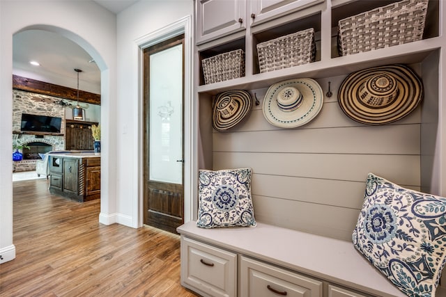 mudroom featuring a stone fireplace and light hardwood / wood-style floors