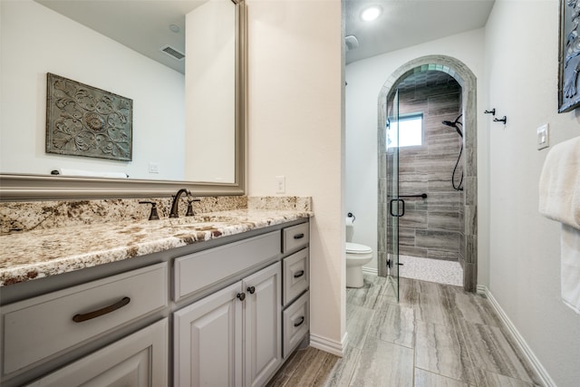 bathroom featuring vanity, toilet, and walk in shower