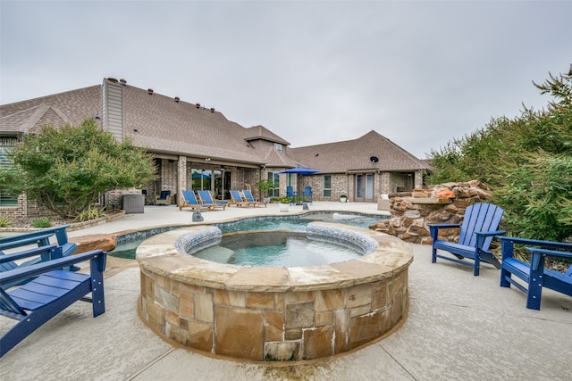 view of pool with a patio area and an in ground hot tub