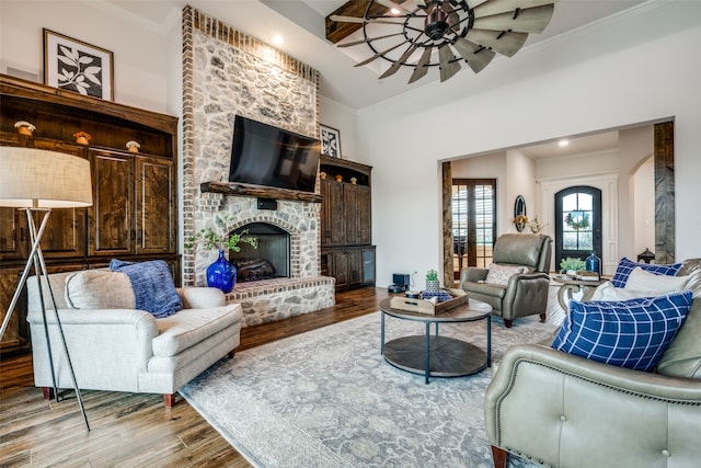 living room with hardwood / wood-style floors, a brick fireplace, and crown molding