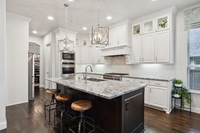 kitchen with custom range hood, appliances with stainless steel finishes, white cabinets, and sink